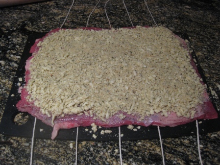 Pounded out flank steak spread with filling & ready to be rolled and tied